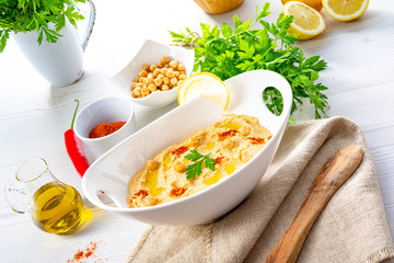 hummus paste with lemon and chilli on white background
