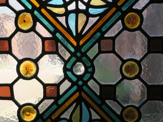 detail of multicolored stained glass window with a geometric pattern
