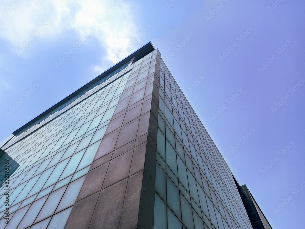 Wall mural modern office building low angle shot cloudy background