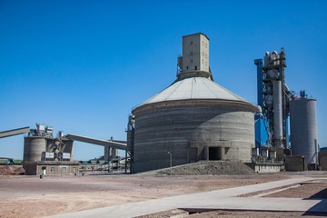 Mixing silo building and conveyor of cement factory (plant) on blue sky background. Mynaral, Kazakhstan, Jambyl Cement plant. © Alexey Rezvykh