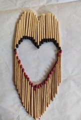 Heart shape with matchstick on white background, closeup