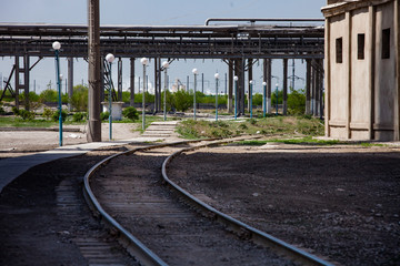 Old soviet railway and pipelines on phosphoric fertilizers plant. Industrial abstract background.