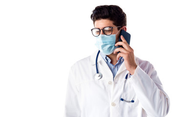 Studio portrait of male doctor talking with sombody on his mobile phone while standing at isolated...