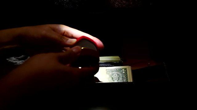 Thief opens the digital safe. Stealing money and valuables at dark night.