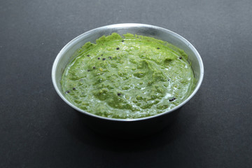 Healthy Indian Green Chutney or Sauce Made using Coriander, Mint And Spices. isolated over moody background. Selective focus