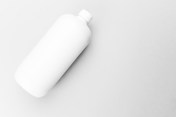 white plastic bottle on a blank surface directly above view