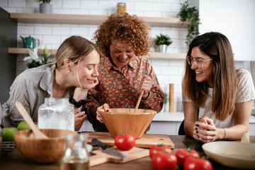 Girlfriends having fun in kitchen. Sisters cooking together..