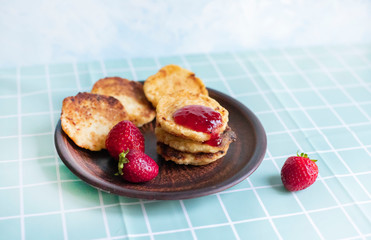 Curd pancakes. Cheesecakes with strawberries and strawberry jam. Healthy breakfast. Proper nutrition, diet.