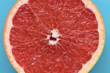 Fresh ruby red grapefruit isolated on light blue background.