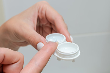 Removes contact lenses for vision correction and places them in a contact lens container