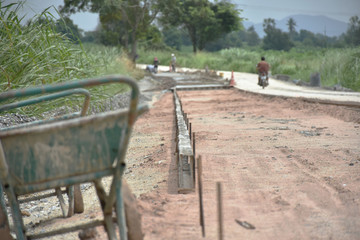 Obraz premium Steel construction formwork for concrete road and cement cart in work area of site construction