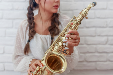 Female with braids and manicure playing the saxophone