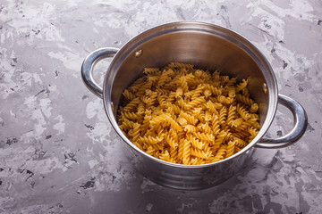 Traditional Italian pasta in a metal pan on a stone background
