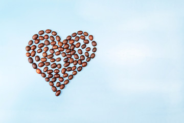 Heart made of coffee beans on a blue background