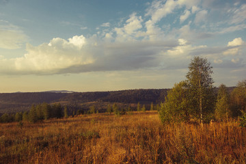 Obraz premium Russia. Travel across Russia. Hills, mountains and fields. Panorama at sunset.