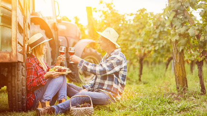 Paar bei Picknick mit Weinprobe im Weinberg
