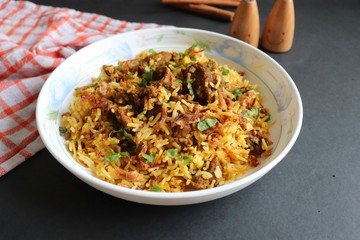 Mutton Biryani or Lamb Pulao. Garnished with fried onion & chopped coriander. Biryani is a famous Spicy non vegetarian dish of India. Goat meat cooked along with Basmati rice & spices. 
