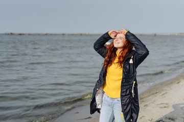 Happy young redhead woman at the seaside © contrastwerkstatt