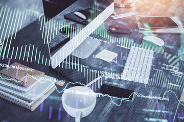 Double exposure of graph and financial info and work space with computer background. Concept of international online trading.