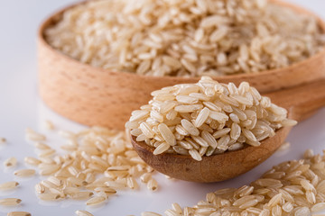 raw brown rice on white acrylic background