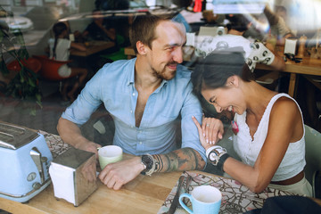 Playful laughing woman and man in cafe