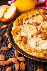 crispy apple galette with almonds on rustic wooden background