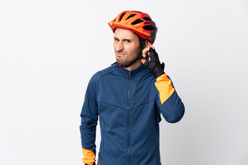 Young cyclist man isolated on white background having doubts