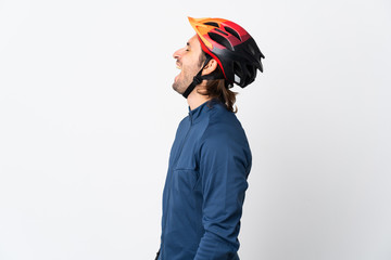 Young cyclist man isolated on white background laughing in lateral position