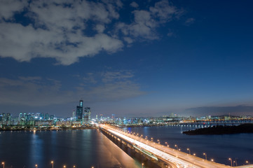 Fototapeta na wymiar The night view of grand bridge background cityscape and blue sky.