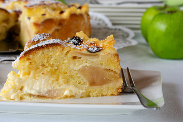 A piece of apple cake on a plate with fork