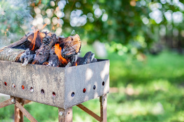 Outdoor recreation.Fiery background. Grunge brazier for barbecue with.firewood in the brazier for barbecue in the garden.