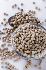 white peppercorns in glass bowl with spoon