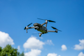 Drone quadcopter in flight over the land
