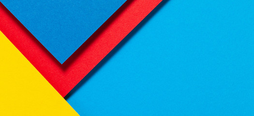 Abstract color papers geometry flat lay composition background with blue, yellow and red color tones