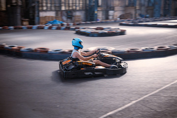 Male driving a kart through a turn on an indoor track