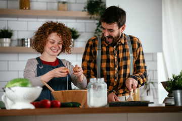 Young couple making delicious food at home. Loving couple enjoying in the kitchen..