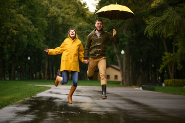 Love couple jumps like a children in rainy day