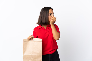 Fototapeta na wymiar Young latin woman holding a grocery shopping bag isolated on white background having doubts
