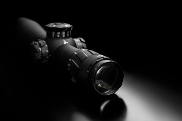 Modern sniper scope on a dark back. Optical device for aiming and shooting at long distances.