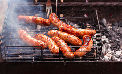 Grilling sausages on barbecue grill. Selective focus