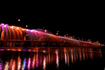 Amazing fantastic colorful fountain with blight at the bridge,