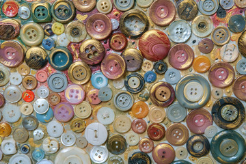 Different color various buttons for clothes on a painted surface