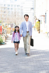 父親と通学する女子小学生