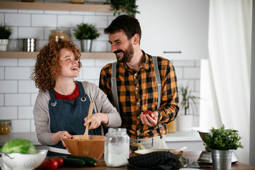 Young couple making delicious food at home. Loving couple enjoying in the kitchen..