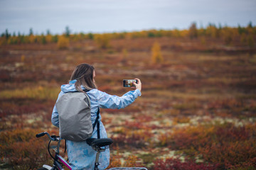 A woman in tundra enjoying scenery of colorful autumn in far north