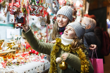 Woman and her daughter are preparing for Christmas and choosing gifts for their family outdoor.