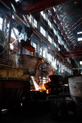 Metallurgy factory workshop. Orange hot melted metal and white smoke (steam). Taraz city, Kazakhstan.