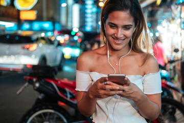 Smiling woman listening music outside stock photo