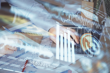 Technology theme hologram with man working on computer on background. High tech concept. Multi exposure.