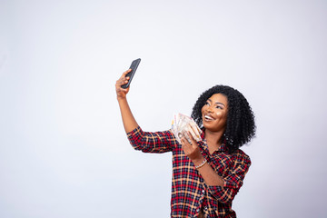 black woman taking a selfie with a wad of cash
